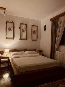 1 dormitorio con 1 cama y algunas fotos en la pared en Cabana Bogdi, en Borşa