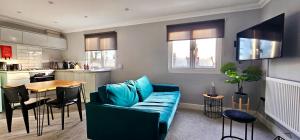 a living room with a blue couch and a table at Victoria House by Switchback Stays in Cardiff