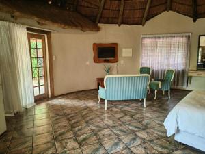 a bedroom with a bed and a table and chairs at La Campagna Olive Estate in Modimolle