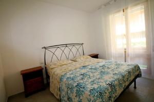 Schlafzimmer mit einem Bett und einem Fenster in der Unterkunft Navigatore in Marina di Grosseto