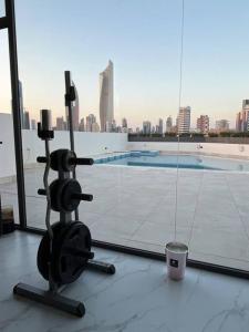 a exercise bike on top of a building with a pool at Serene roof A quiet romantic luxurious in Kuwait