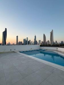 a swimming pool on the roof of a building with a city skyline at Serene roof A quiet romantic luxurious in Kuwait