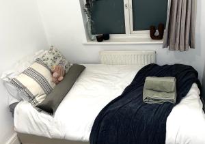 a small bedroom with a white bed and a window at Powdermill Lodge in Hanworth