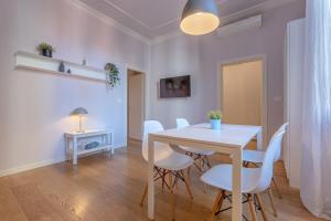 ein Esszimmer mit einem weißen Tisch und weißen Stühlen in der Unterkunft Bolo Stay Central Apartment in Bologna