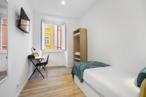 a white bedroom with a bed and a desk at Smart Living Hub: Designer Spaces for Digital Nomads & Remote Workers in Lisbon