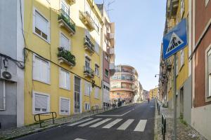 an empty street in a city with yellow buildings at Smart Living Hub: Designer Spaces for Digital Nomads & Remote Workers in Lisbon