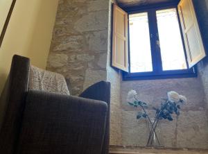 a vase of flowers in a vase under a window at Hotel Rural Restaurante Las Baronas in Santa Cruz de la Salceda