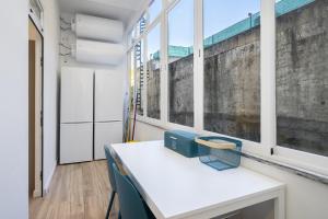 Smart Living Hub: Designer Spaces for Digital Nomads & Remote Workers في لشبونة: غرفة مع طاولة بيضاء ونوافذ
