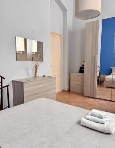 a white bedroom with a bed and a bathroom at Butera Apartments in Bagheria
