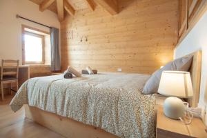 a bedroom with a bed with a wooden wall at Begale - Rifugio Urbano in Rotzo