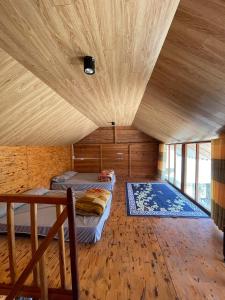 a room with two beds and a wooden ceiling at Chú Ba Farmstay - cách Đà Lạt 40km 