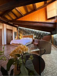 a bedroom with a bed and a table at Hotel Rural Restaurante Las Baronas in Santa Cruz de la Salceda