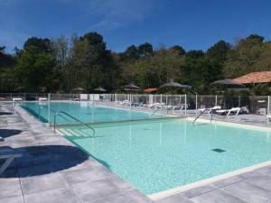 een groot zwembad met stoelen en parasols bij Camping Les Goélands - Maeva in Arès