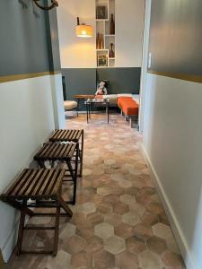 濱海聖布里阿克的住宿－La suite Émile proposé par escaleasaintbriac，走廊上设有两把长椅和一只狗坐在桌子上