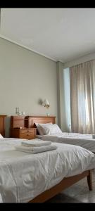 um quarto com 2 camas com lençóis brancos e uma janela em ESPERIA CITY HOTEL DRAMA em Drama