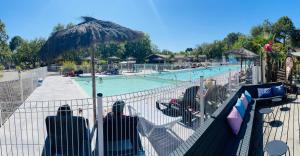 un grupo de personas sentadas en sillas frente a una piscina en Camping Les Goélands - Maeva, en Arès