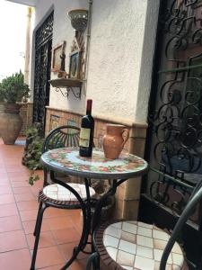 a table with a bottle of wine and a vase on it at Hotel Fernanda in Letojanni