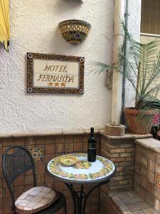 a table with a bottle of wine sitting on a patio at Hotel Fernanda in Letojanni