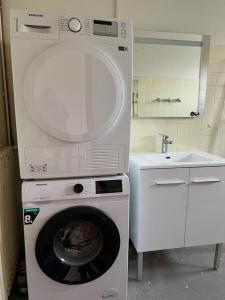 uma máquina de lavar roupa numa cozinha com um lavatório em Maison 8 personnes à la campagne à 8 km des plages em Notre-Dame-de-Riez