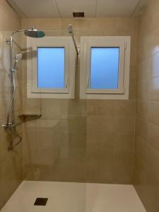 uma casa de banho com um chuveiro e 2 janelas em Maison 8 personnes à la campagne à 8 km des plages em Notre-Dame-de-Riez