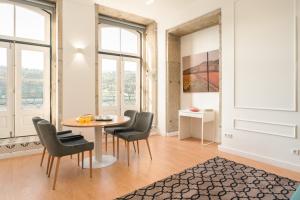 a dining room with a table and chairs and windows at Romantic Douro River & Sunset views in Porto