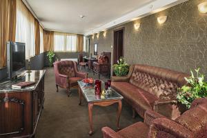 a living room with a couch and chairs and a tv at Park Hotel Moskva in Sofia