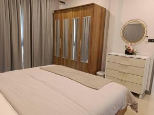 1 dormitorio con cama, espejo y tocador en Beautiful Villa with private pool in Cha-Am, en Ban Sahakham