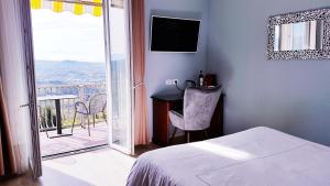 um quarto com uma cama e uma varanda com uma televisão em Villa Bellavista Alba, B&B em Alba