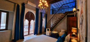 a bedroom with a bed and a staircase with blue curtains at Riad de Vincent in Marrakesh