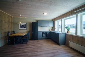 a kitchen with a wooden table and a wooden floor at Bjorli Fjellstuer - by Classic Norway Hotels in Bjorli