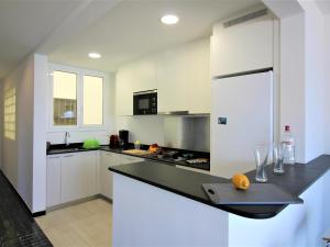 a kitchen with white cabinets and a black counter top at Apartamento Roses, 2 dormitorios, 6 personas - ES-258-76 in Roses