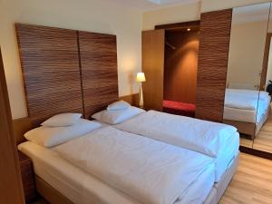 ein Hotelzimmer mit 2 Betten und einem Spiegel in der Unterkunft Hotel Heide Kröpke in Essel