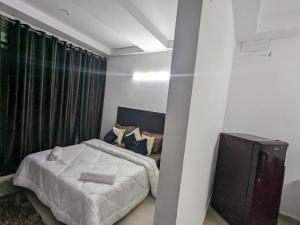 a bedroom with a bed and a large window at VVA HOMES in Ghaziabad