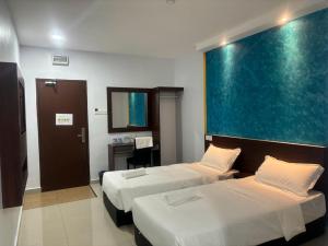 a hotel room with two beds and a large window at Codidik Hotel in Kuantan