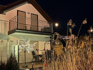 ein Haus mit einem Balkon, einem Tisch und Stühlen in der Unterkunft Villa di Lago - Ferienhaus mit Sauna in Mücheln