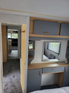 Habitación pequeña con escritorio y espejo. en 15 bluebell lane en Hastings