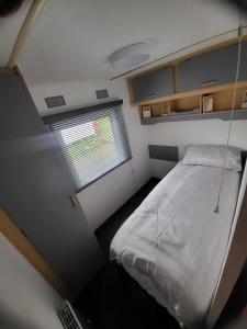 Habitación pequeña con cama y ventana en 15 bluebell lane, en Hastings