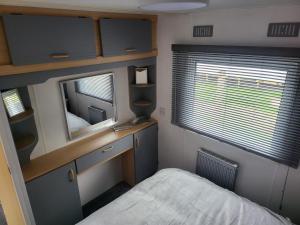 a small bedroom with a bed and a mirror at 15 bluebell lane in Hastings