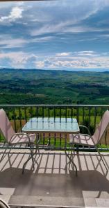 a table and chairs on a balcony with a view at Villa Bellavista Alba, B&B in Alba