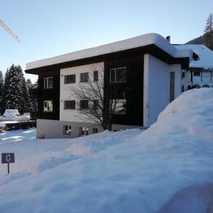 a building with a pile of snow in front of it at Chalet Alberti Davos Platz in Davos