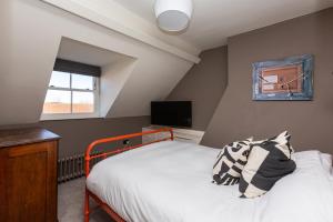 1 dormitorio con 1 cama y TV en la pared en Lewknor Lodge: Stunning 5 bed, 4 bathroom house in Ramsgate en Kent