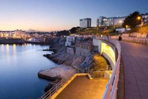 a bridge over a river in a city at night at The Lockett by StayStaycations in Plymouth