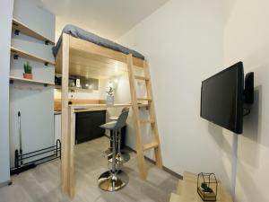 een kleine kamer met een stapelbed en een bureau bij Le Bilongue in Rodez