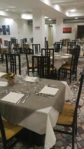 ein Esszimmer mit Tischen und Stühlen in einem Restaurant in der Unterkunft Sacro Cuore Hotel in Massa