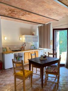 - une cuisine avec une table et des chaises en bois dans la chambre dans l'établissement La Casetta, à Pievina