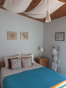 Stylish maisonette only 2min walk to the beach في كيفيريون: غرفة نوم مع سرير وبطانية زرقاء