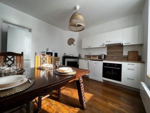 uma cozinha com uma mesa de madeira com placas em Grand F2 proche du centre ville. em Châlons-en-Champagne