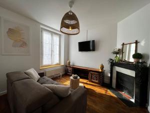 a living room with a couch and a fireplace at Grand F2 proche du centre ville. in Châlons-en-Champagne