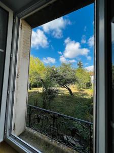 uma janela com vista para um campo e árvores em Grand F2 proche du centre ville. em Châlons-en-Champagne