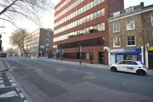 a white car parked on the side of a city street at 3-Bed Apartment in King's Cross Central London in London